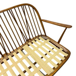 Load image into Gallery viewer, A close-up of a wooden armchair with a curved backrest made of vertical slats and a light beige woven slat seat, shown on a plain white background.
