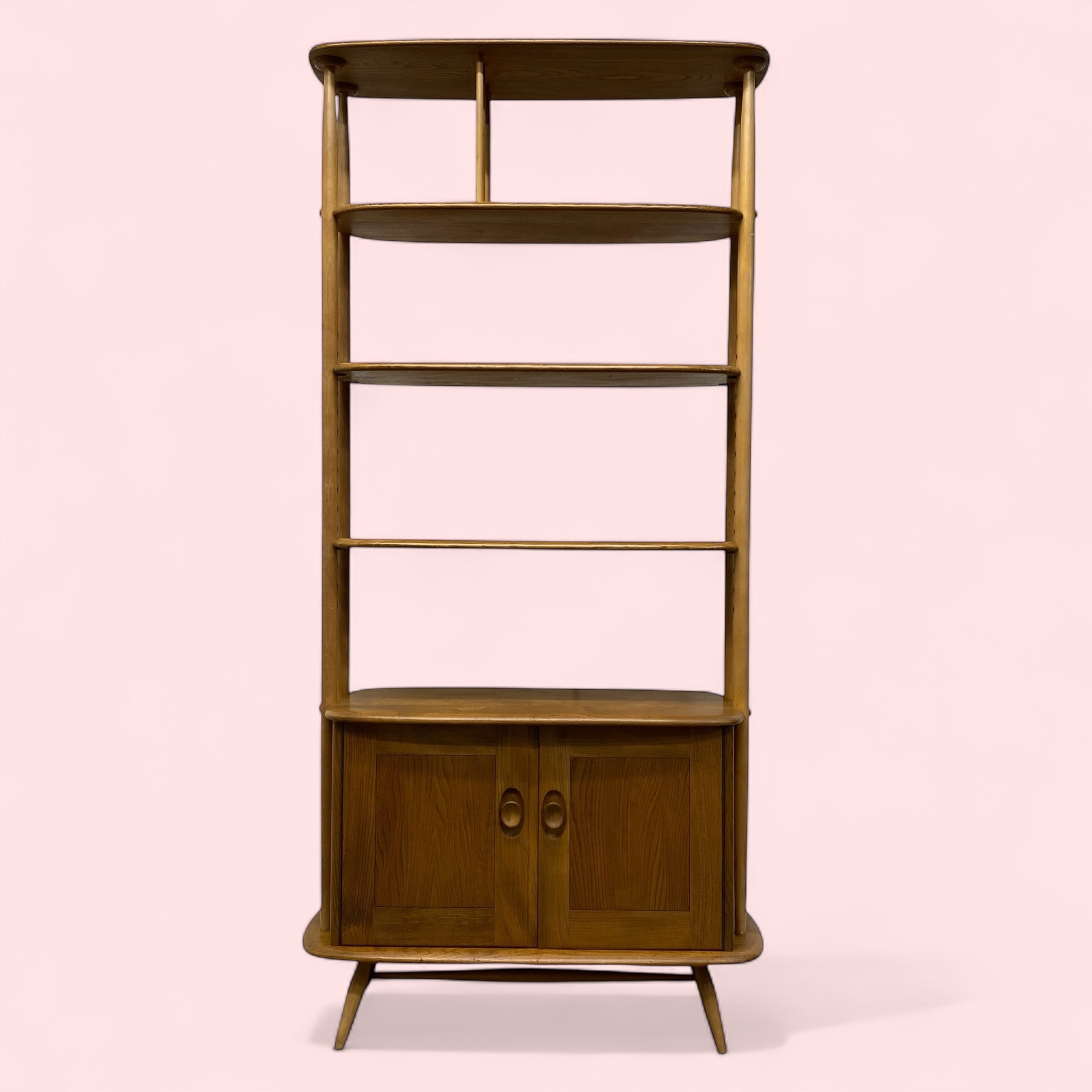 Wooden bookshelf with four shelves on a pink background