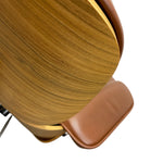 Load image into Gallery viewer, Close-up of a modern chair featuring a curved backrest with a warm golden-brown wood grain finish and a smooth brown leather seat, set against a solid white background.
