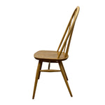 Load image into Gallery viewer, A single wooden dining chair with a spindle back and angled legs, shown from a side profile view against a plain white background.
