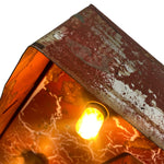 Load image into Gallery viewer, Close-up of a rustic metal lamp shade with a weathered rusted brown and silver surface, featuring a glowing warm yellow light inside.
