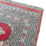 Load image into Gallery viewer, Close-up of a patterned rug with red and blue designs
