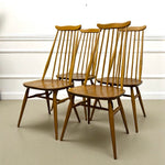 Load image into Gallery viewer, Set of four wooden chairs in a room with white walls and a light-colored floor.
