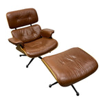 Load image into Gallery viewer, A mid-century modern lounge chair with an attached ottoman, upholstered in warm brown leather with gold-toned metal trim and black swivel legs, shown on a plain white background.
