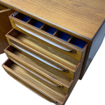 Load image into Gallery viewer, A close-up of a wooden drawer unit with four open drawers, showing a warm medium-brown wood grain finish and blue fabric lining inside the top compartment.
