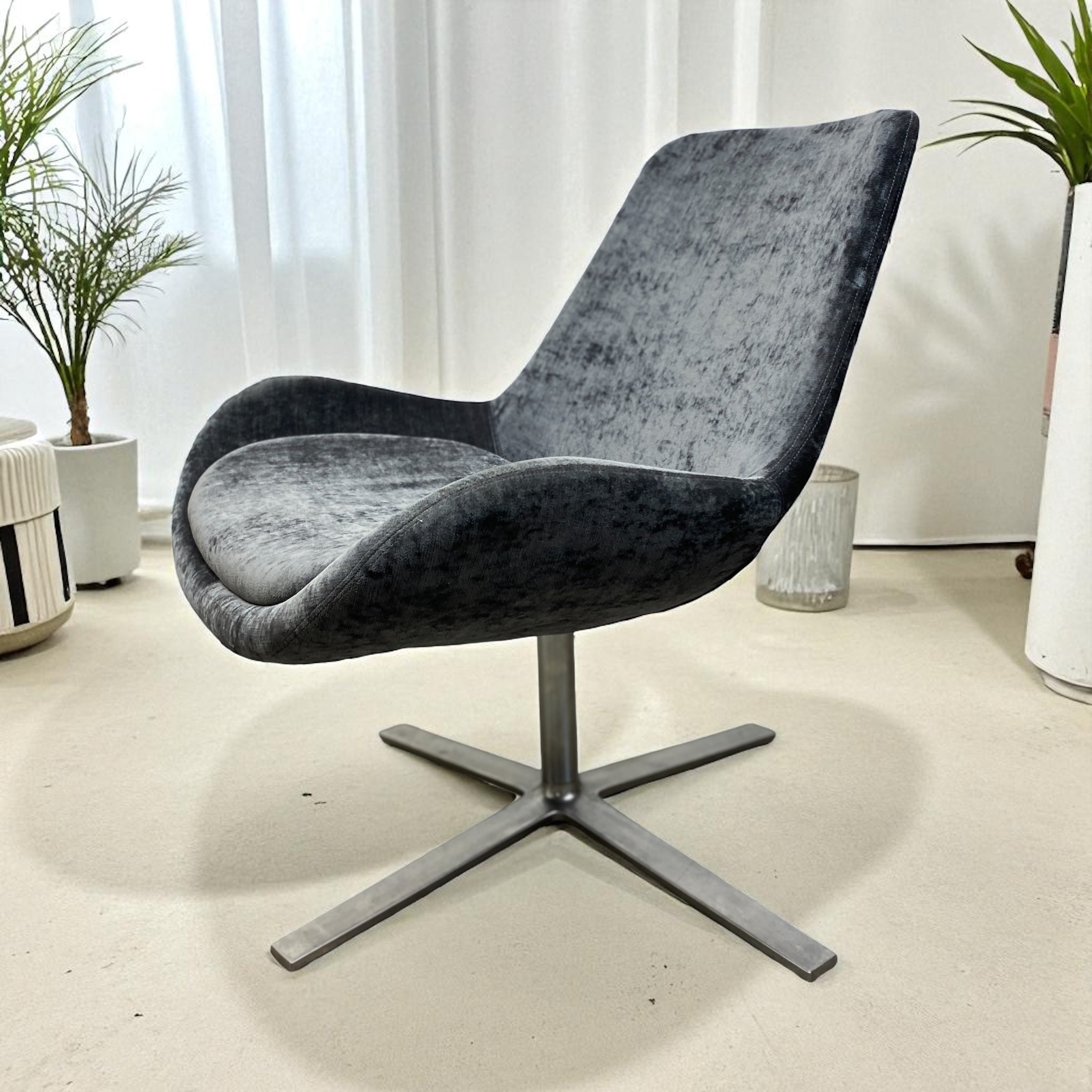 grey swivel office chair with curtains and plants