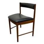 Load image into Gallery viewer, A mid-century modern wooden dining chair with a warm brown wood frame and black leather upholstered seat and backrest, shown on a plain white background.
