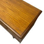 Load image into Gallery viewer, Close-up of a wooden furniture piece showing a warm medium-brown wood grain finish with a rounded corner and drawer front detail on a white background.
