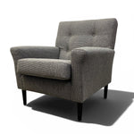 Load image into Gallery viewer, A modern gray upholstered armchair with a tufted backrest and dark tapered legs, shown on a white background with a soft shadow.
