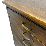 Load image into Gallery viewer, Close-up of a dark brown wooden dresser with three drawers and brass handles, showing the wood grain and texture against a white background.
