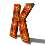 Load image into Gallery viewer, A large decorative letter K light fixture with a copper-toned metallic finish, white crackle-style marbling, and built-in warm white LED bulbs, shown on a white background with a soft shadow.
