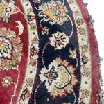 Load image into Gallery viewer, Close-up of a patterned rug with intricate designs in red, black, and beige.
