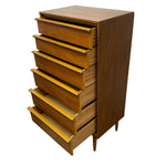 Load image into Gallery viewer, A mid-century modern wooden chest of drawers with six drawers, some pulled out, showcasing a warm medium-brown wood grain finish and tapered legs on a white background.
