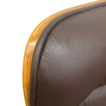 Load image into Gallery viewer, Close-up detail of a brown textured leather chair back with a curved wooden edge on a white background.
