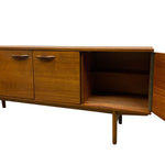 Load image into Gallery viewer, Mid-century modern wooden sideboard cabinet with two closed doors, an open side door showing shelving, and tapered legs, photographed against a plain white background.
