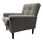 Load image into Gallery viewer, A modern gray upholstered accent chair with a tufted backrest and tapered black legs, shown from a three-quarters angle on a white background.
