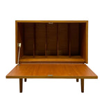 Load image into Gallery viewer, A mid-century modern wooden storage cabinet with its door open, showing a warm honey-toned wood grain finish and internal dividers, set against a plain white background.
