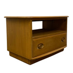 Load image into Gallery viewer, A mid-century modern wooden side table or media console with a warm honey-brown finish, featuring a single drawer with round knobs and an open shelf.
