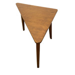 Load image into Gallery viewer, A triangular wooden side table with a warm medium-brown finish and tapered legs, shown from an elevated angle against a plain white background.

