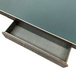 Load image into Gallery viewer, A close-up of a dark wood desk drawer pulled open, showing a muted blue-green tabletop surface above it, isolated on a white background.
