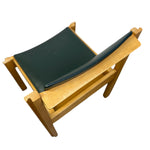 Load image into Gallery viewer, A modern wooden armchair with a light natural wood frame and a dark green curved seat cushion, shown from an elevated angle against a white background.

