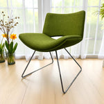 Load image into Gallery viewer, Green chair with metal legs in a room with large windows and plants.
