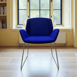 Load image into Gallery viewer, Blue chair in a room with large windows and a radiator.
