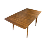 Load image into Gallery viewer, A mid-century modern wooden dining table with a rich grain pattern, shown from an elevated angle against a plain white background.
