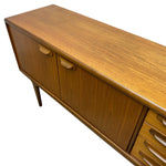 Load image into Gallery viewer, Mid-century modern wooden sideboard cabinet with a warm honey oak finish, featuring two cabinet doors with curved wooden pulls and a slatted drawer front on the right, shown against a plain white background.
