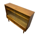 Load image into Gallery viewer, Mid-century modern wooden display cabinet with glass doors and drawers, shown on a plain white background.
