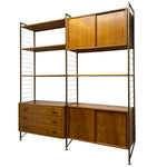 Load image into Gallery viewer, Wooden wall unit with shelves and drawers on a white background
