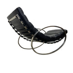 Load image into Gallery viewer, A modern black leather lounge chair with a curved tubular steel frame, shown from a side angle against a plain white background.
