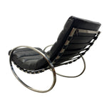 Load image into Gallery viewer, A mid-century modern lounge chair with black leather cushions and a polished chrome metal frame, shown from a three-quarters angle against a plain white background.
