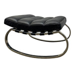 Load image into Gallery viewer, A modern black leather ottoman with a tufted cushioned seat and a curved polished metal base, shown against a plain white background.
