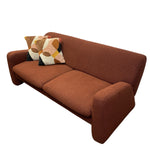 Load image into Gallery viewer, A mid-century modern two-seater sofa upholstered in a warm rust-brown textured fabric, featuring two decorative throw pillows with a geometric pattern, set against a plain white background.
