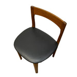 Load image into Gallery viewer, A mid-century modern wooden dining chair with a warm brown wood frame and a black upholstered seat cushion, shown from an elevated angle on a white background.
