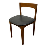 Load image into Gallery viewer, A mid-century modern wooden dining chair with a warm brown teak wood frame and a black upholstered seat, shown against a plain white background.
