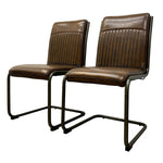 Load image into Gallery viewer, Two matching brown leather dining chairs with vertical channel tufting on the backrests and black cantilever metal legs, shown against a plain white background.
