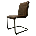 Load image into Gallery viewer, A brown leather dining chair with a ribbed vertical backrest and a black cantilever metal base, shown against a plain white background.
