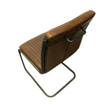 Load image into Gallery viewer, A brown leather dining chair with a black metal frame and cantilever base, shown from an elevated angle against a white background.
