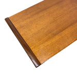 Load image into Gallery viewer, A close-up of a medium brown wooden tabletop corner showing the wood grain and a dark brown beveled edge, isolated on a white background.
