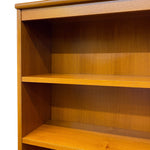 Load image into Gallery viewer, Close-up of a wooden bookshelf with three shelves, showing a warm medium-brown wood grain finish against a plain white background.
