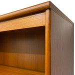 Load image into Gallery viewer, Close-up of a wooden bookshelf corner showing the warm medium-brown wood grain, top rail, shelf edge, and open storage space against a plain white background.
