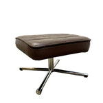 Load image into Gallery viewer, A brown leather ottoman with a tufted square cushion and a chrome four-star metal base, shown against a plain white background.
