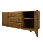 Load image into Gallery viewer, A mid-century modern wooden sideboard cabinet with three drawers, a cabinet door, an open storage compartment with a shelf, and small black caster wheels, shown on a plain white background.
