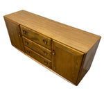 Load image into Gallery viewer, A mid-century modern wooden sideboard cabinet with three drawers and one cabinet door, featuring a warm honey-brown wood finish and round metal knobs, shown on a plain white background.
