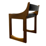 Load image into Gallery viewer, A mid-century modern wooden chair with a warm brown walnut-look frame and black leather seat and backrest, shown from a three-quarters angle on a white background.
