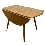 Load image into Gallery viewer, A mid-century modern wooden drop-leaf table with a warm medium-brown wood finish, shown on a solid white background.
