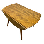 Load image into Gallery viewer, A mid-century modern wooden drop-leaf table with a warm honey-toned wood finish, shown on a solid white background.
