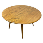 Load image into Gallery viewer, A round wooden dining table with a warm medium-brown finish and four tapered legs, shown on a plain white background.
